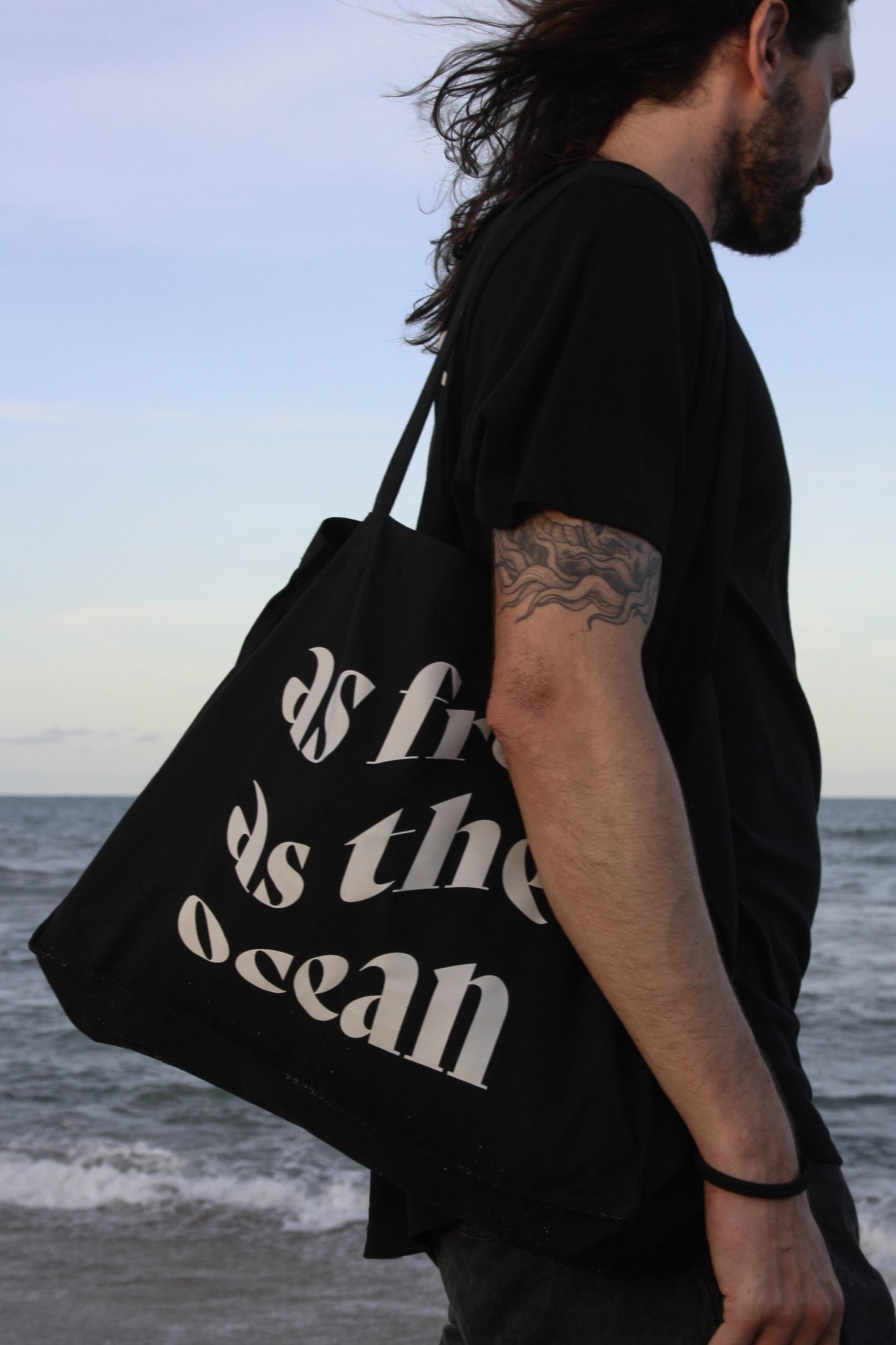 Male model wearing AFATO 'As Free As The Ocean' beachbag – designed with the perfect blend of functionality, style, and eco-conscious materials.