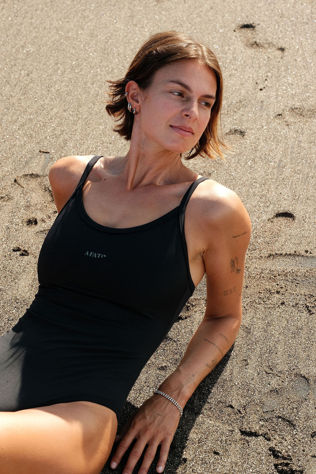 Model wearing AFATO Oceansuit in black at the beach – combining style, comfort, and surf performance.