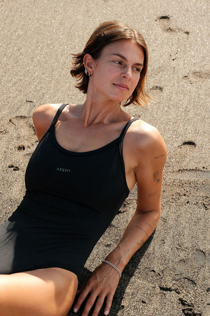 Model wearing AFATO Oceansuit in black at the beach – combining style, comfort, and surf performance.