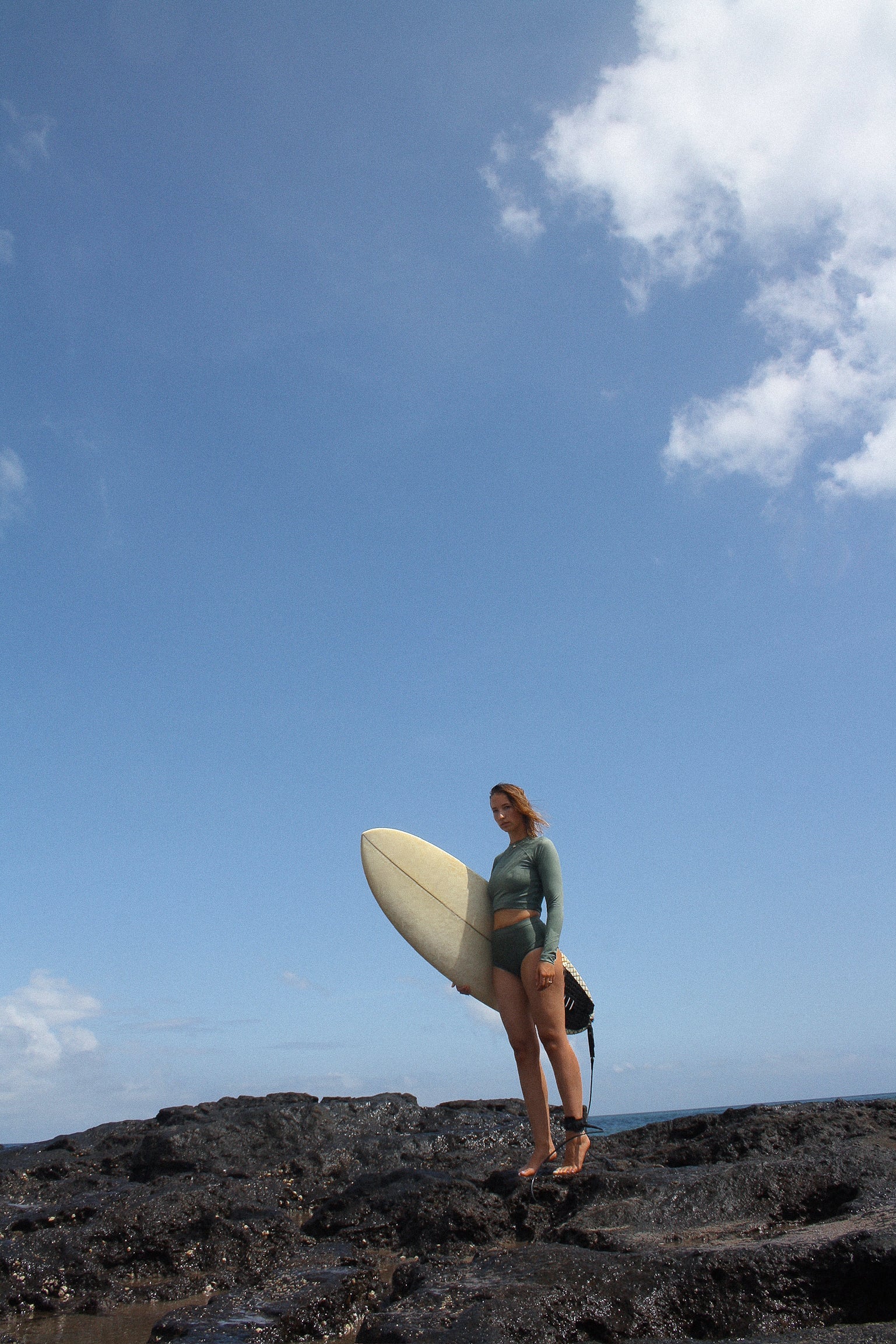 AFATO model holding surfboard on the beach – ready for adventure with style and confidence.