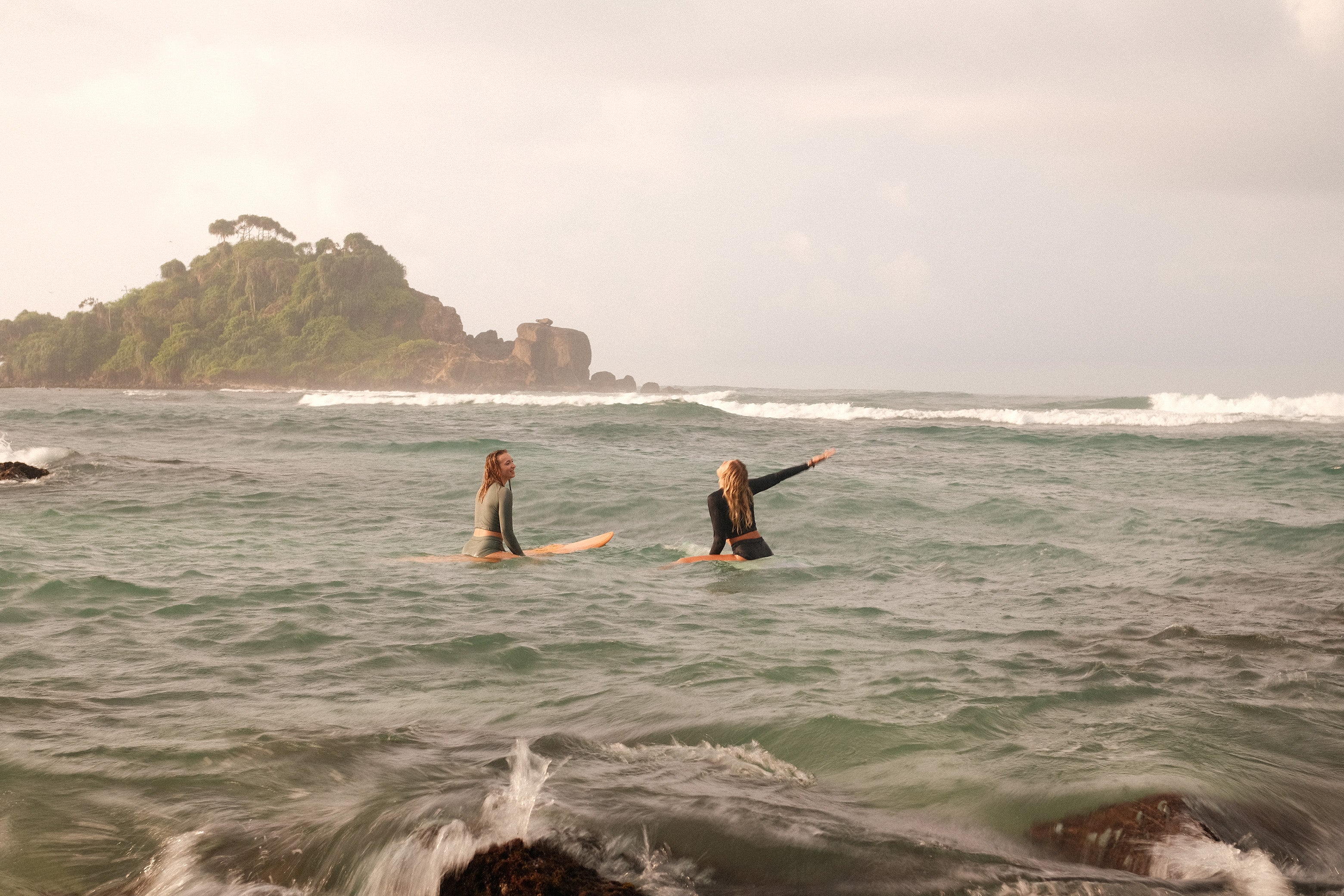 Duo in AFATO surfwear: black and sage green sets, ideal for active beach days and stylish surf sessions.